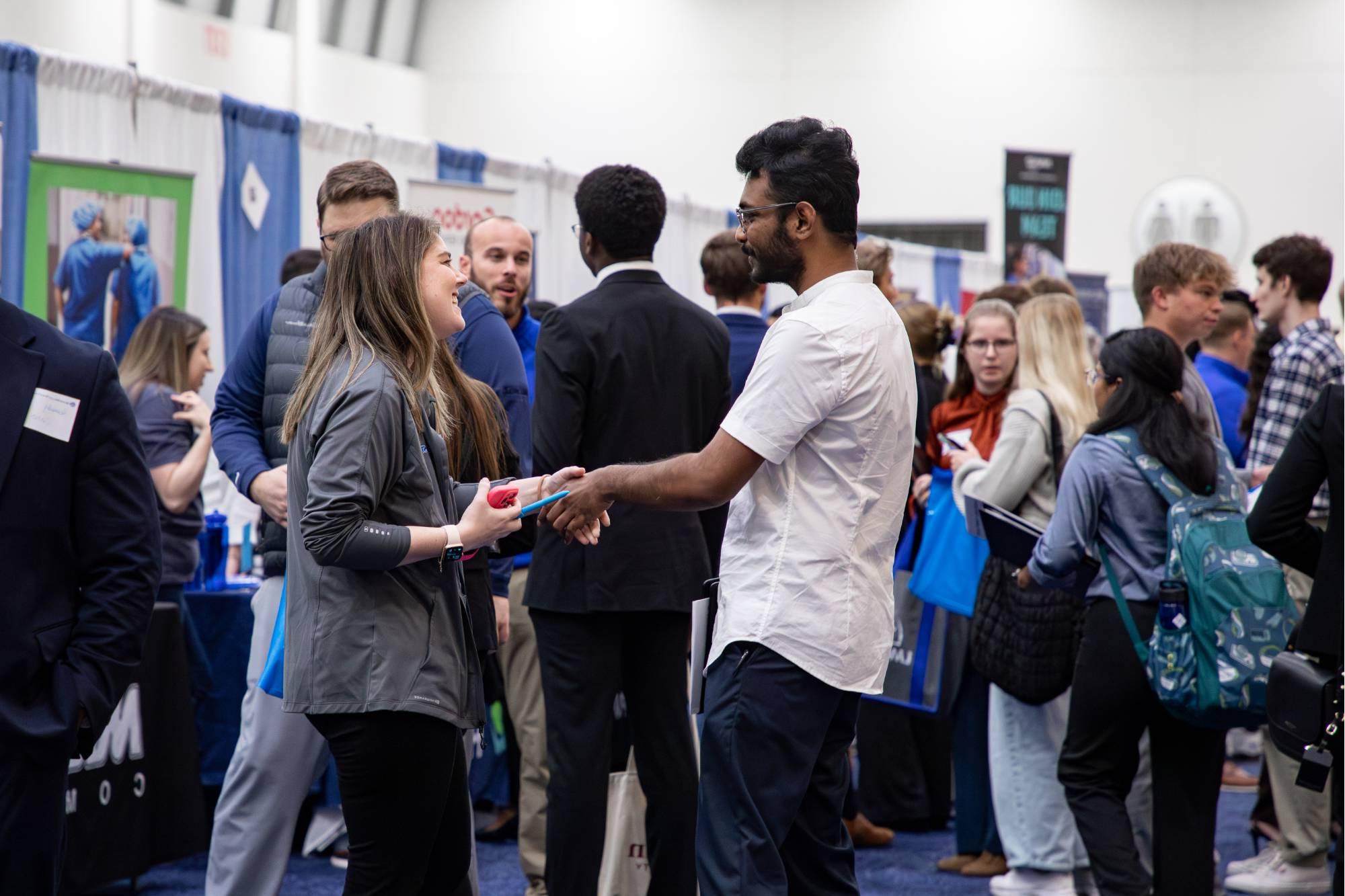 people shaking hands at career fair